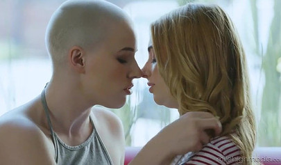 Dashing blonde babe and a bald chick enjoy soft lesbian fucking on a red couch