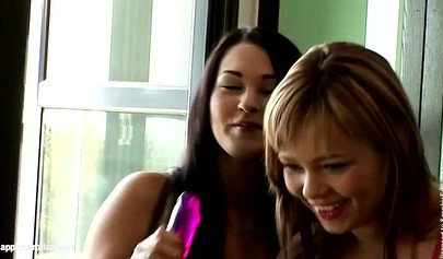 Young lesbians sit side by side and rub their pussies before fucking each other