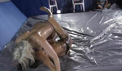 Oil wrestling of two stunning girls in a professional studio