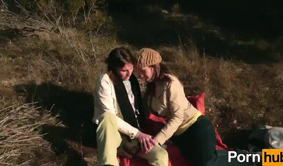 Amateur chicks kissing and using a big strap-on outdoors