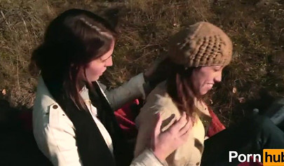 Amateur chicks kissing and using a big strap-on outdoors