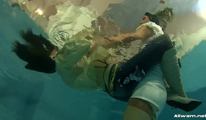 Gorgeous ladies swim in the pool and excite each other