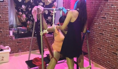 Asian lesbians practice bondage in a BDSM room