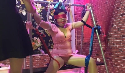 Asian lesbians practice bondage in a BDSM room