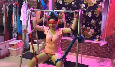 Asian lesbians practice bondage in a BDSM room