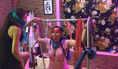 Asian lesbians practice bondage in a BDSM room