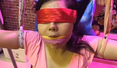 Asian lesbians practice bondage in a BDSM room