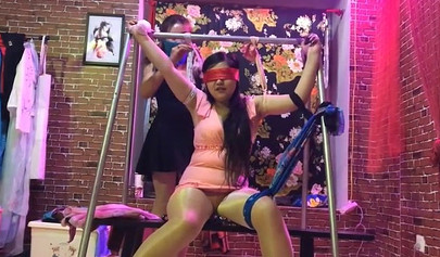 Asian lesbians practice bondage in a BDSM room