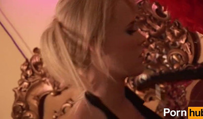 Busty MILFs practice strap-on sex in a glamorous room