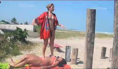 Cute lesbian beauties practice trampling on the beach