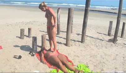 Cute lesbian beauties practice trampling on the beach