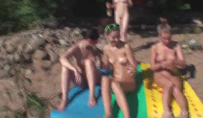 Outdoor lesbian foursome on a nude beach under the sun