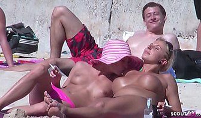 Lesbian couple spends time together on a nude beach