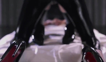 Eine in Latex gekleidete Lesbe vögelt eine heiße Blondine mit einem Strap-On.