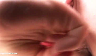 Eine sexy Brünette kniet nieder und befriedigt die enge Muschi ihrer Freundin mit den Fingern.