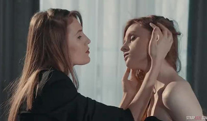 Two hot redhead lesbians are enjoying a strapon fuck