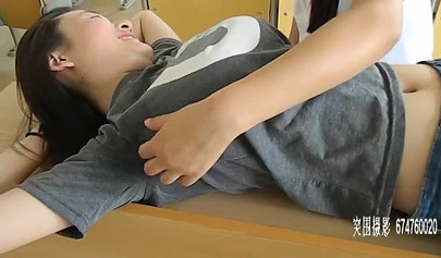 Chinese girls tickle each other in the classroom