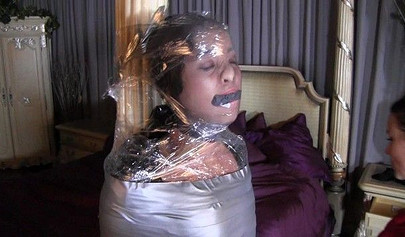 Two mature ladies enjoy a mummification fetish in the bedroom