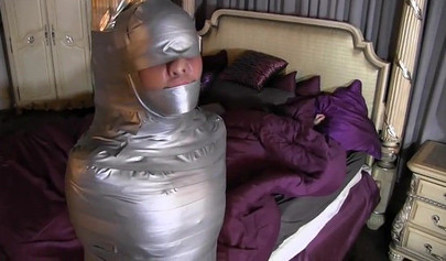 Two mature ladies enjoy a mummification fetish in the bedroom
