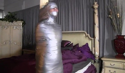 Two mature ladies enjoy a mummification fetish in the bedroom