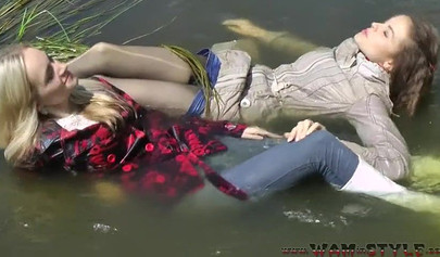 Attractive girls are swimming in clothes in the river