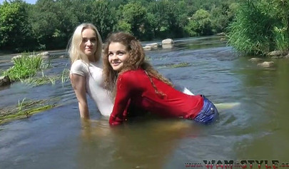 Attractive girls are swimming in clothes in the river