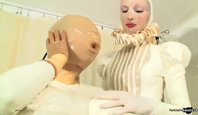 Девушки в белых латексных костюмах принимают участие в фетиш-видео.