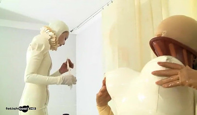 Девушки в белых латексных костюмах принимают участие в фетиш-видео.