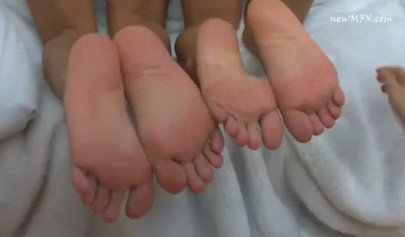 Three beautiful girls are enjoying foot worship in the living room